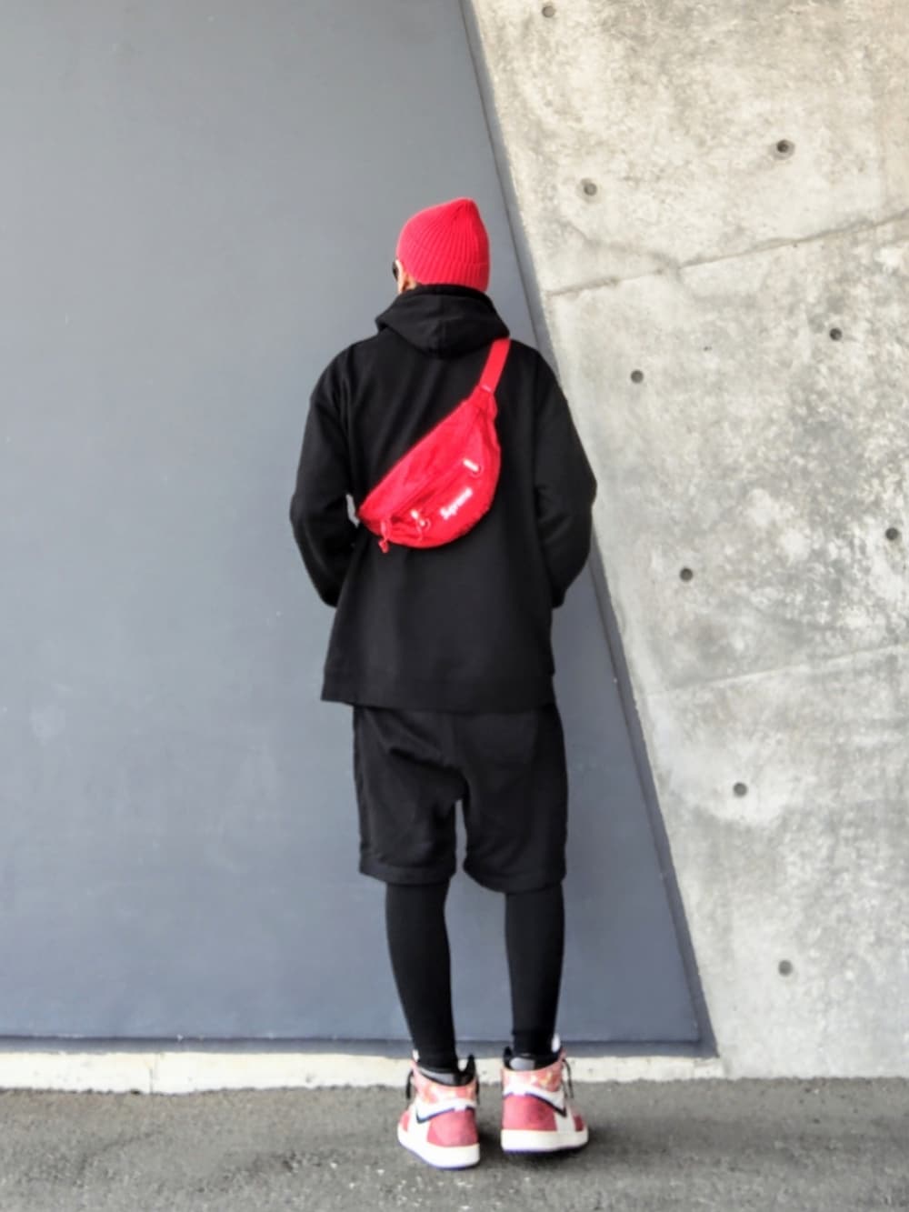レッド系のボディバッグ/ウエストポーチ、ブラック系のパーカー、ブラック系のその他パンツを着用したメンズの春コーディネートの2枚目の写真