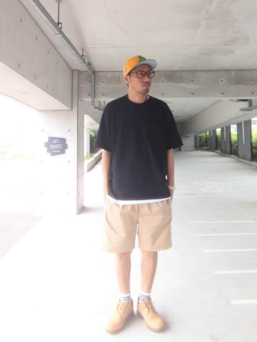 ブラック系のTシャツ/カットソー、ベージュ系のチノパンツ、イエロー系のブーツを着用したメンズの春コーディネートの2枚目の写真