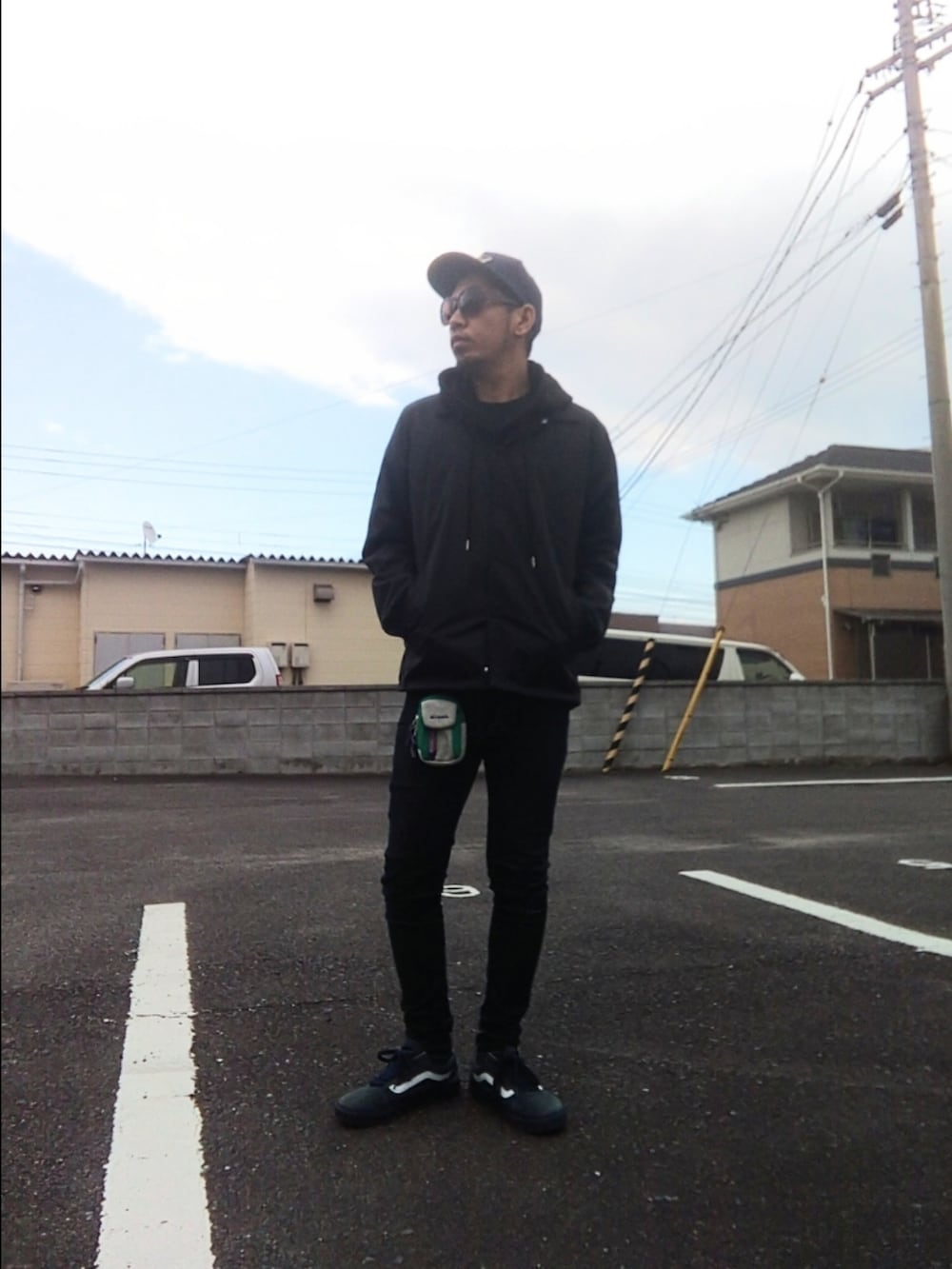 ブルー系のスニーカー、ブルー系のナイロンジャケット、ブルー系のデニムパンツを着用したメンズの冬コーディネートの3枚目の写真