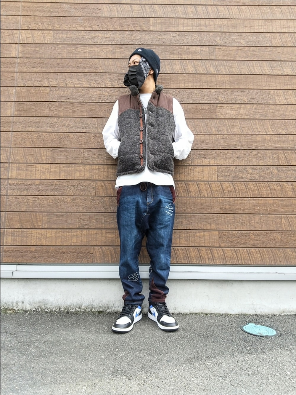 グレー系のベスト、ホワイト系のTシャツ/カットソー、ブルー系のデニムパンツを着用したメンズの秋コーディネートの2枚目の写真