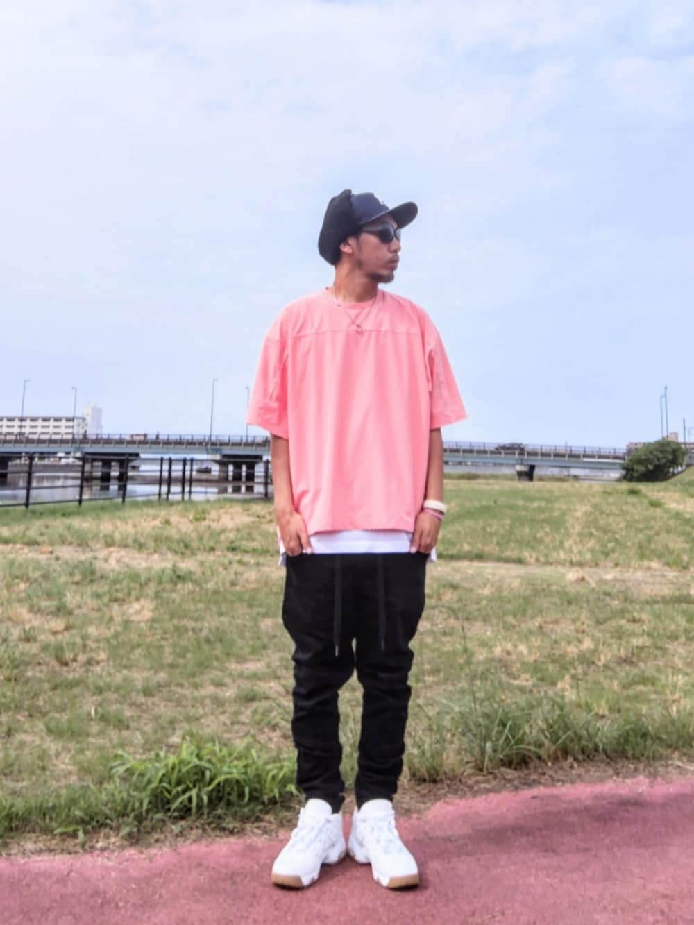 ピンク系のTシャツ/カットソー、ホワイト系のタンクトップ、ブラック系のデニムパンツを着用したメンズの秋コーディネートの2枚目の写真