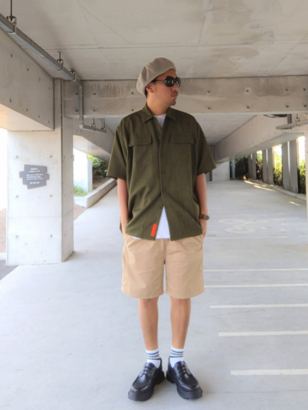 グリーン系のシャツ/ブラウス、ブラック系のモカシン/デッキシューズ、ベージュ系のチノパンツを着用したメンズの秋コーディネートの3枚目の写真