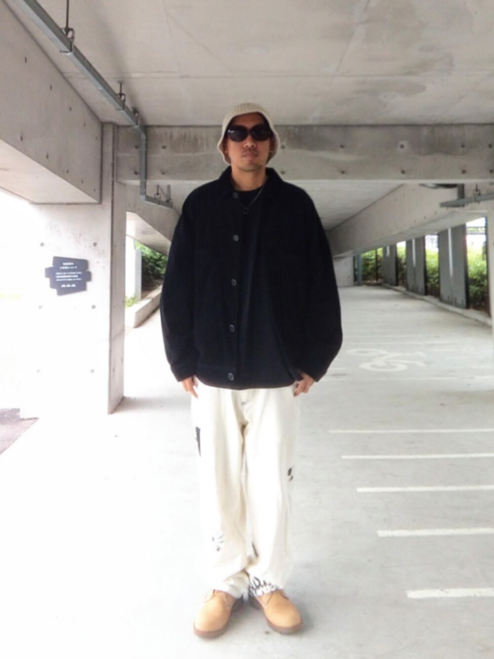ブラック系のジャケット/アウター、ブラック系のTシャツ/カットソー、ホワイト系のデニムパンツを着用したメンズの春コーディネートの2枚目の写真