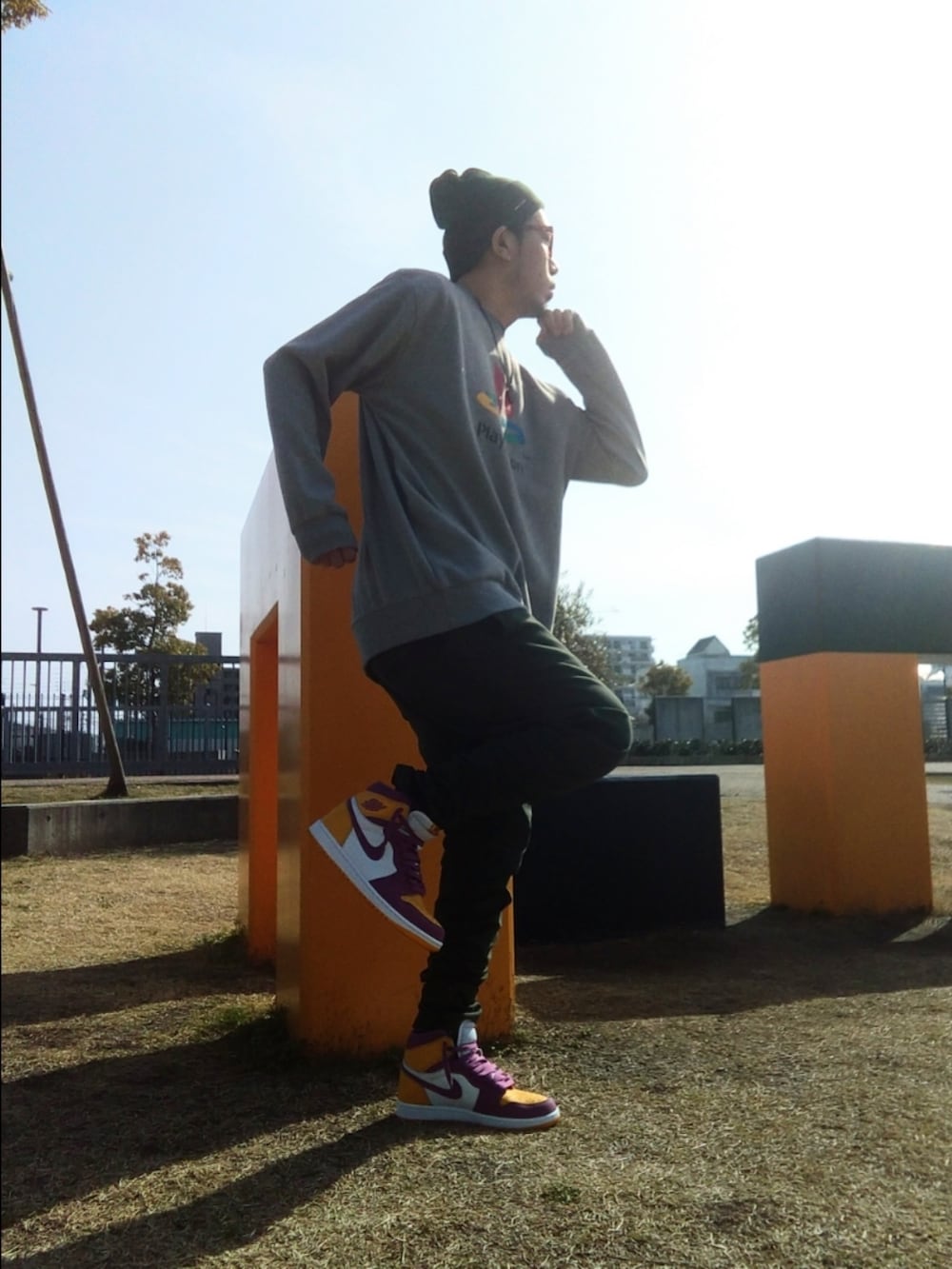 グリーン系のパンツ、グレー系のスウェット、イエロー系のスニーカーを着用したメンズの春コーディネートの2枚目の写真