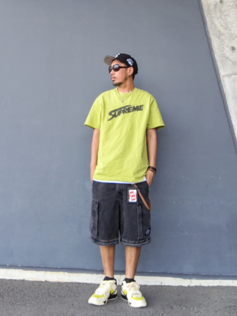 グリーン系のTシャツ/カットソー、ブラック系のその他パンツ、その他のスニーカーを着用したメンズの夏コーディネートの2枚目の写真
