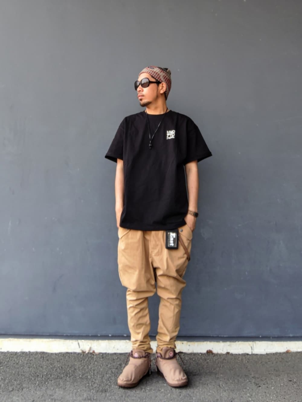 ブラック系のTシャツ/カットソー、ベージュ系のその他パンツ、ブラウン系のスニーカーを着用したメンズの夏コーディネートの2枚目の写真