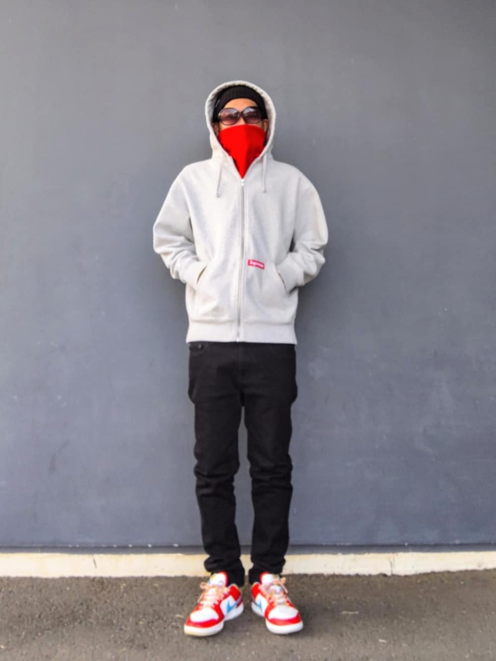 グレー系のパーカー、ブラック系のデニムパンツ、その他のスニーカーを着用したメンズの冬コーディネートの3枚目の写真