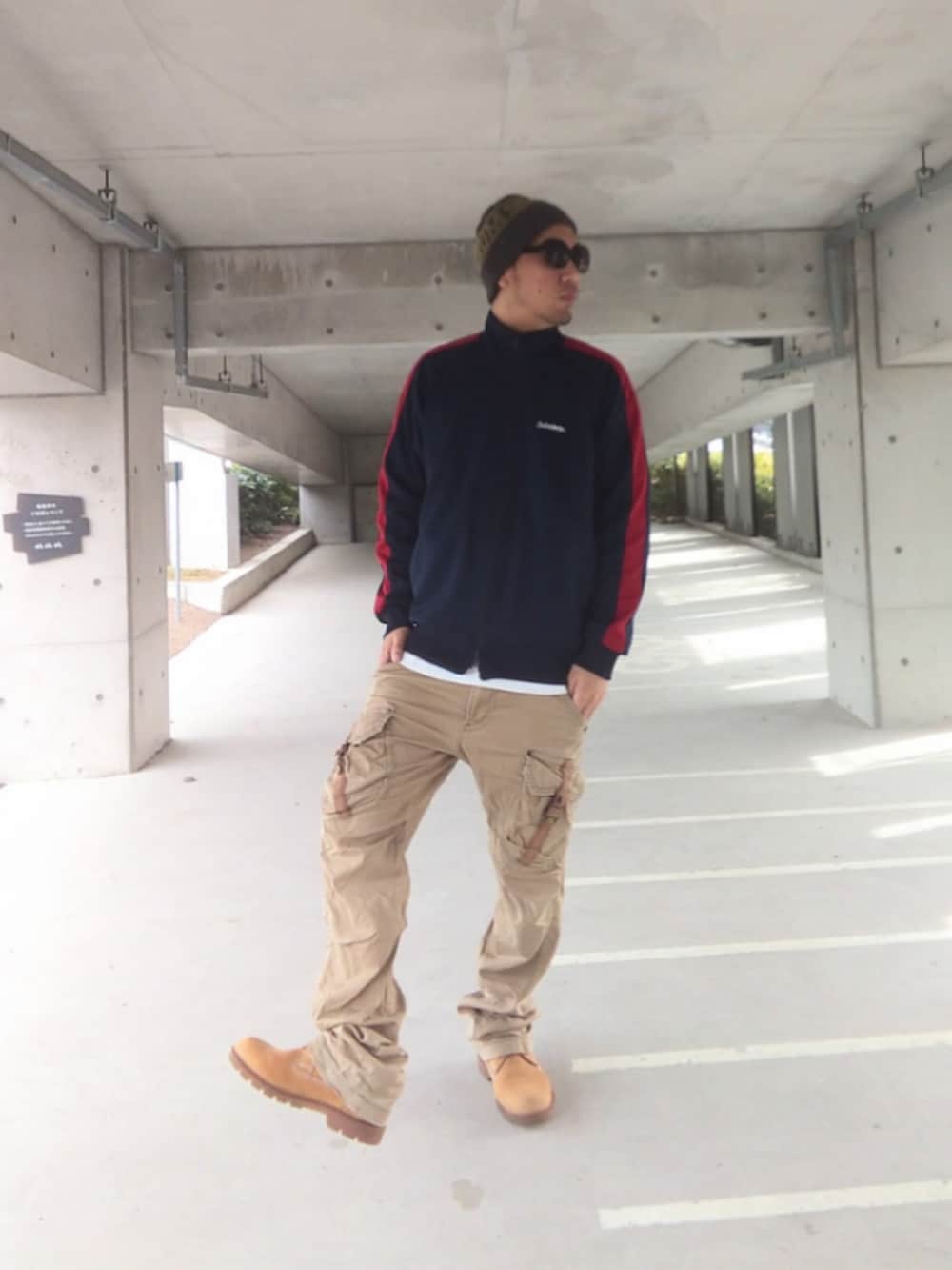 ブルー系のジャージ、ベージュ系のカーゴパンツ、イエロー系のブーツを着用したメンズの春コーディネートの2枚目の写真