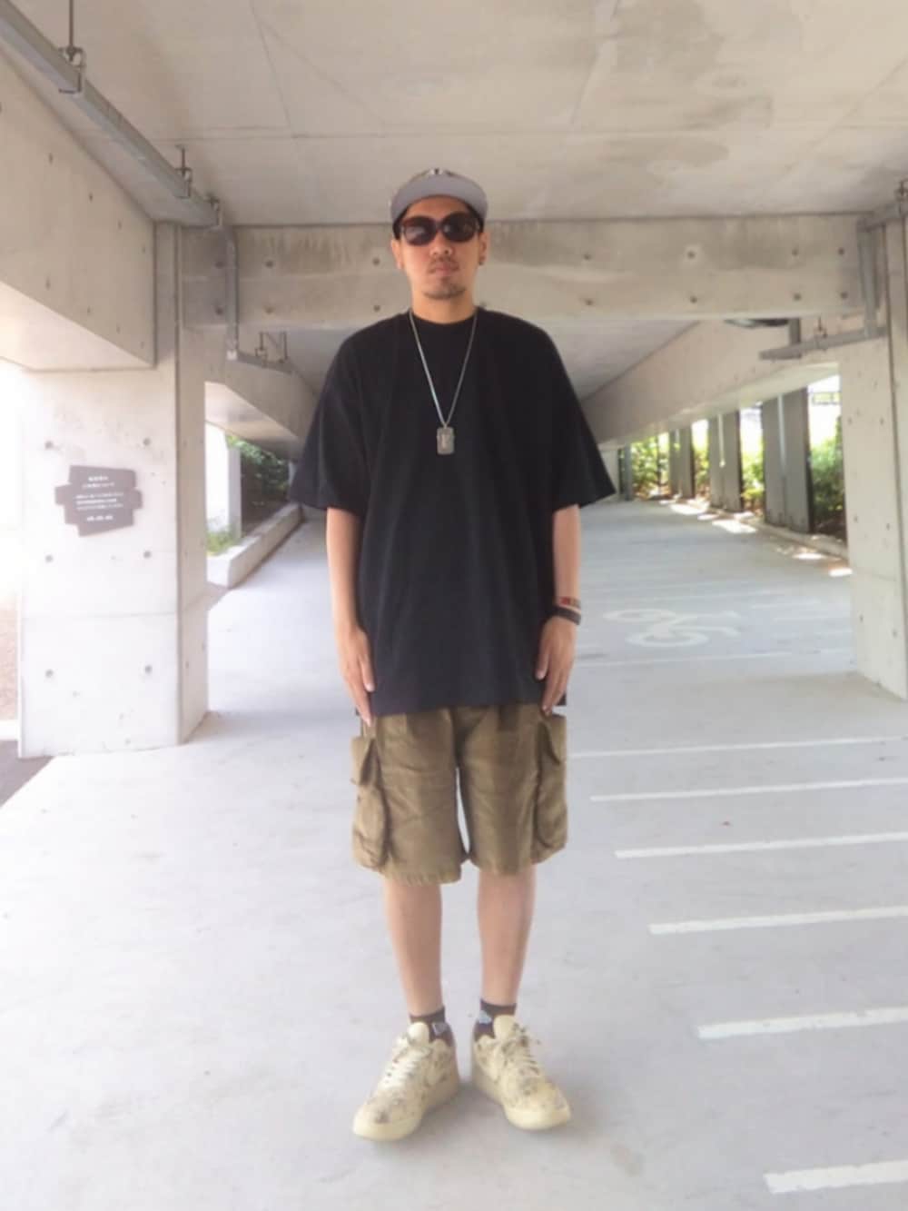 ブラック系のTシャツ/カットソー、グリーン系のその他パンツ、ベージュ系のスニーカーを着用したメンズの夏コーディネートの2枚目の写真