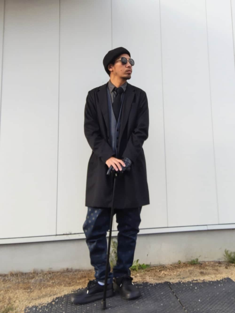 ブラック系のチェスターコート、ブラック系のシャツ/ブラウス、ブルー系のその他パンツを着用したメンズの春コーディネートの3枚目の写真