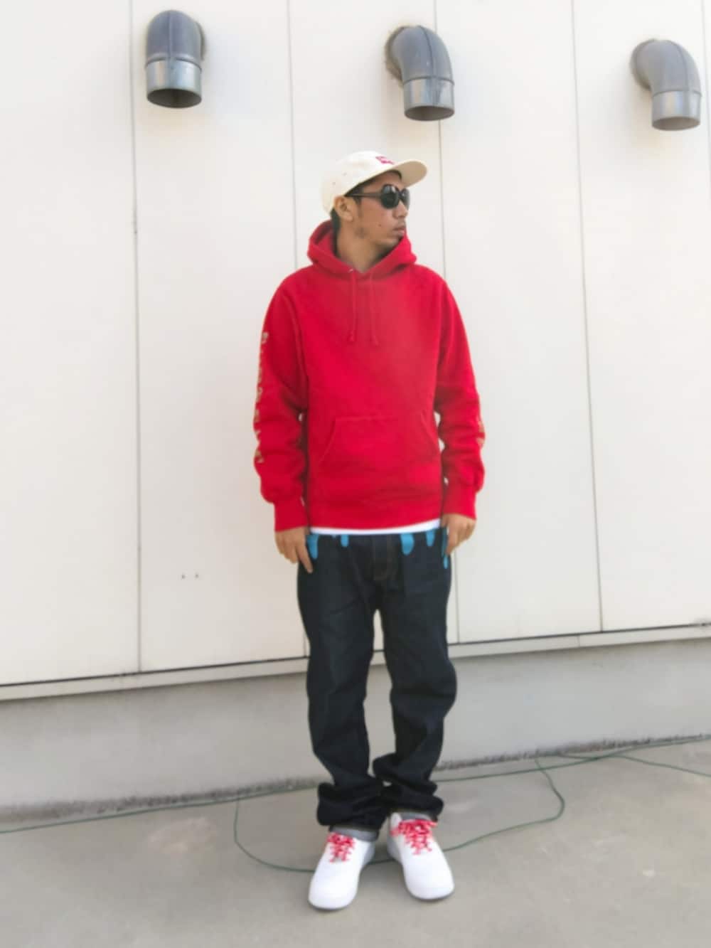 レッド系のパーカー、ホワイト系のタンクトップ、ブルー系のデニムパンツを着用したメンズの秋コーディネートの2枚目の写真