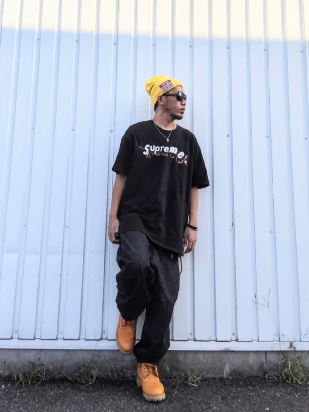 ブラック系のTシャツ/カットソー、ブルー系のデニムパンツ、イエロー系のブーツを着用したメンズの秋コーディネートの2枚目の写真