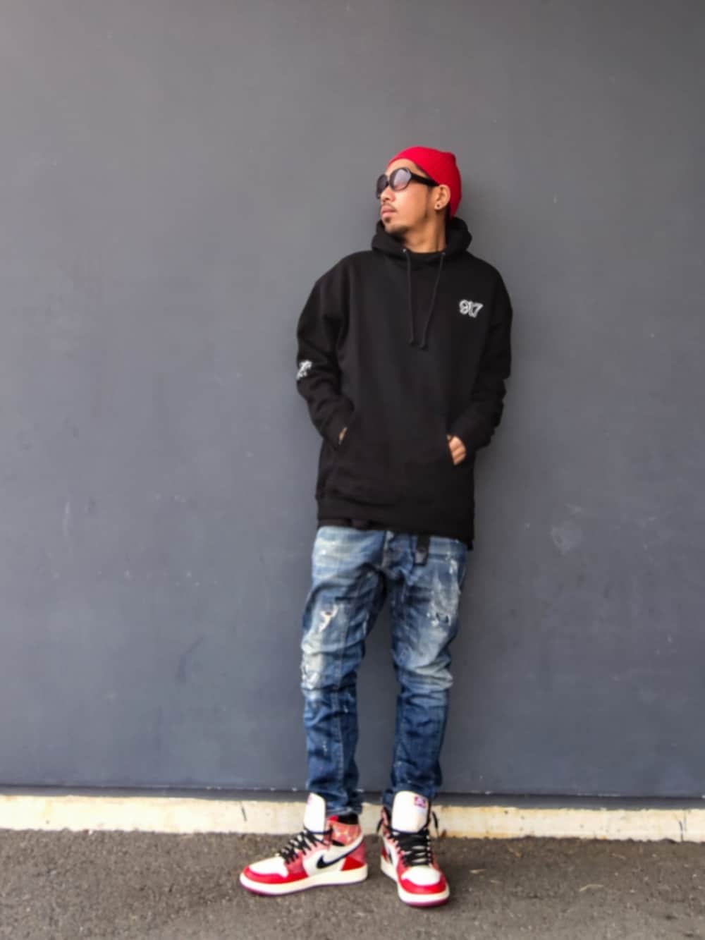 ブラック系のパーカー、ブルー系のデニムパンツ、レッド系のスニーカーを着用したメンズの冬コーディネートの2枚目の写真