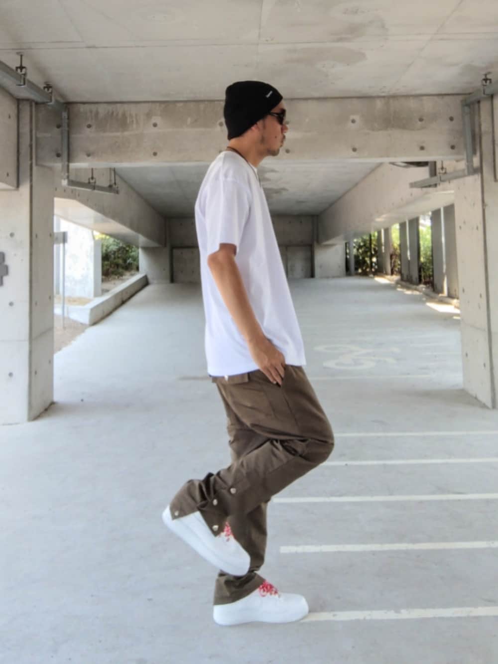 ホワイト系のTシャツ/カットソー、グリーン系のその他パンツ、ホワイト系のスニーカーを着用したメンズの夏コーディネートの3枚目の写真