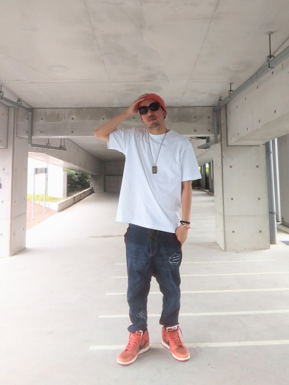 ホワイト系のTシャツ/カットソー、ブルー系のデニムパンツ、オレンジ系のスニーカーを着用したメンズの夏コーディネートの2枚目の写真