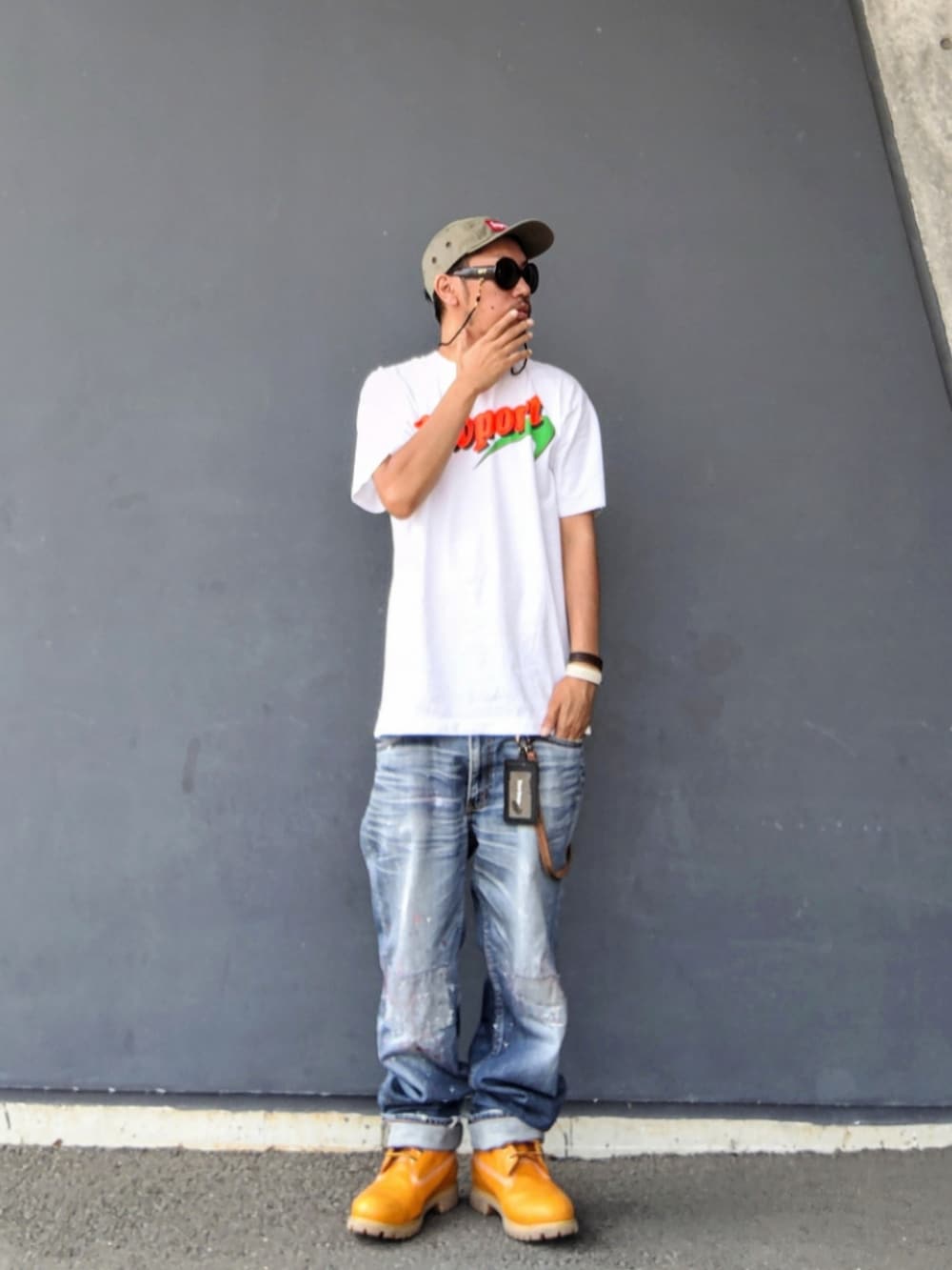 ホワイト系のTシャツ/カットソー、ブルー系のデニムパンツ、イエロー系のブーツを着用したメンズの夏コーディネートの2枚目の写真
