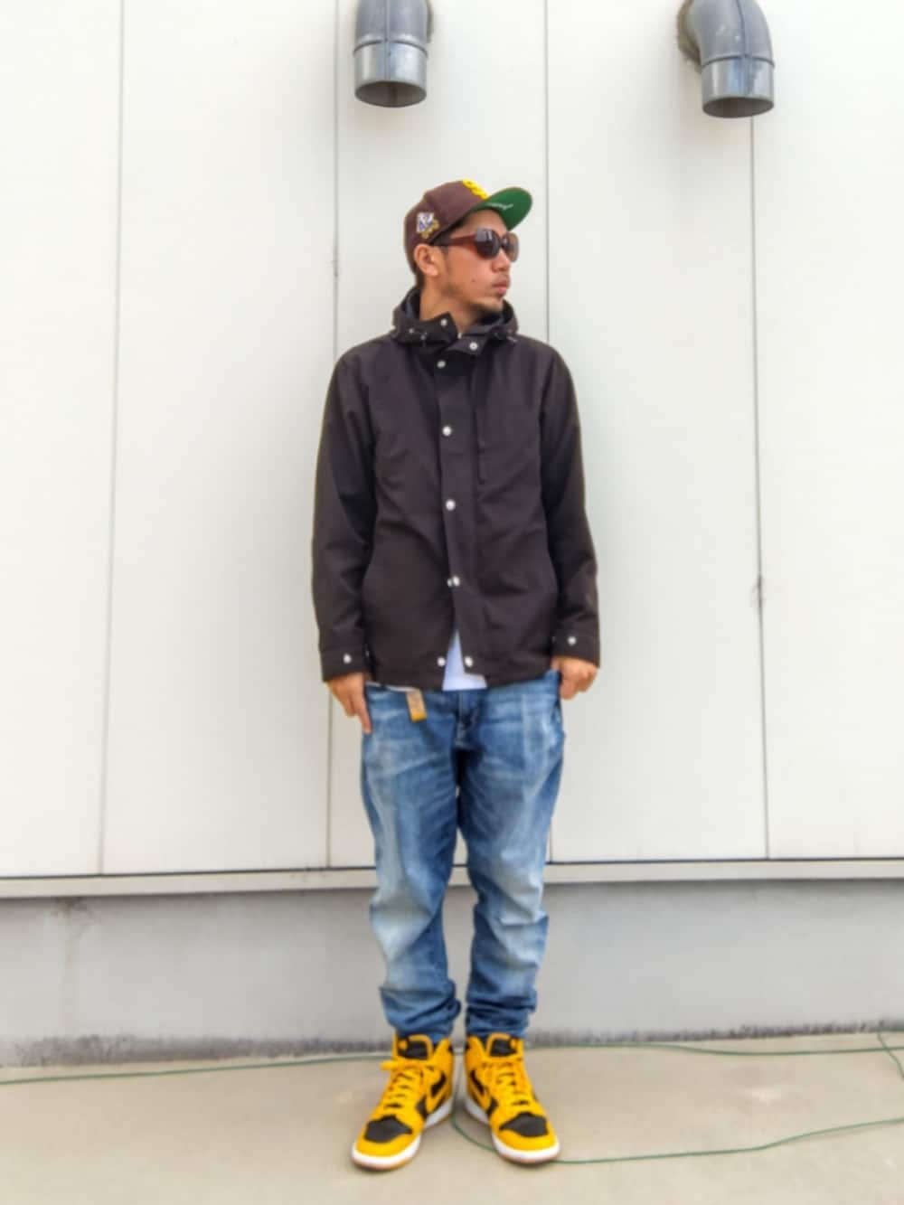 ブラック系のマウンテンパーカー、ホワイト系のTシャツ/カットソー、ブルー系のデニムパンツを着用したメンズの秋コーディネートの2枚目の写真