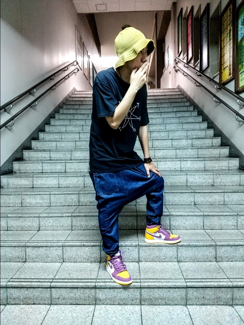 レッド系のTシャツ/カットソー、ブルー系のデニムパンツ、ホワイト系のスニーカーを着用したメンズの秋コーディネートの4枚目の写真