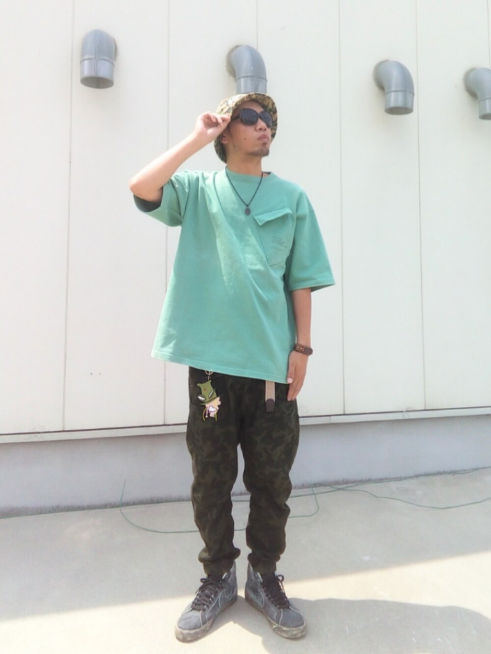 グリーン系のTシャツ/カットソー、その他のパンツ、ブラック系のスニーカーを着用したメンズの夏コーディネートの2枚目の写真