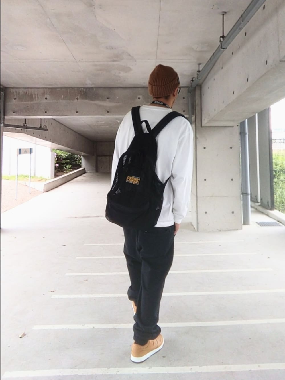 ブラウン系のスニーカー、ブラック系のスウェットパンツ、ホワイト系のTシャツ/カットソーを着用したメンズの春コーディネートの3枚目の写真