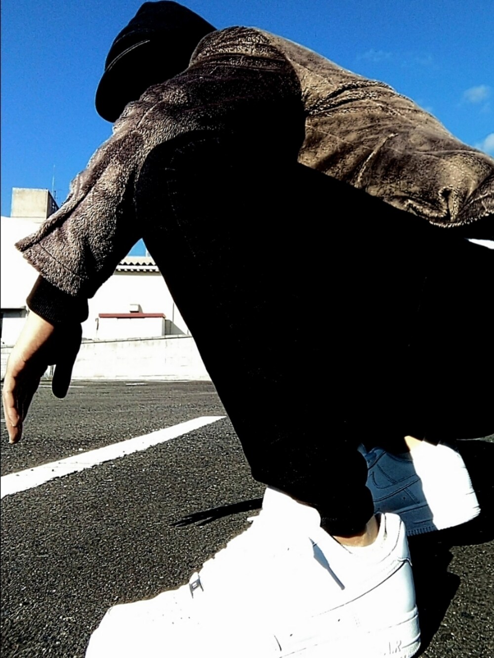 ホワイト系のスニーカー、ブラック系のデニムパンツ、ブラック系のパーカーを着用したメンズの冬コーディネートの3枚目の写真