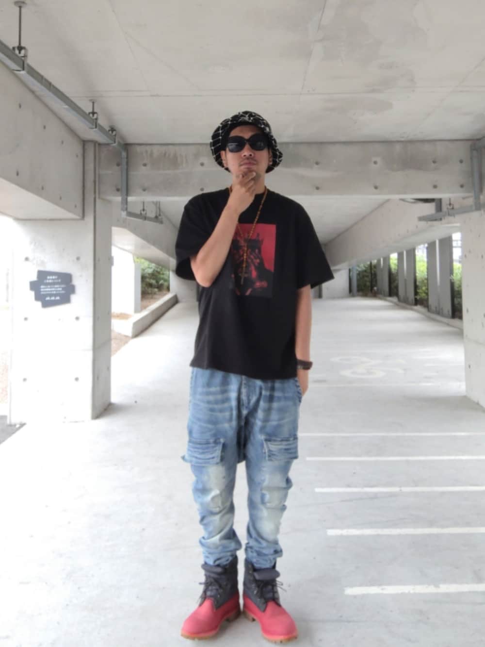 ブラック系のTシャツ/カットソー、ブルー系のデニムパンツ、レッド系のブーツを着用したメンズの夏コーディネートの2枚目の写真