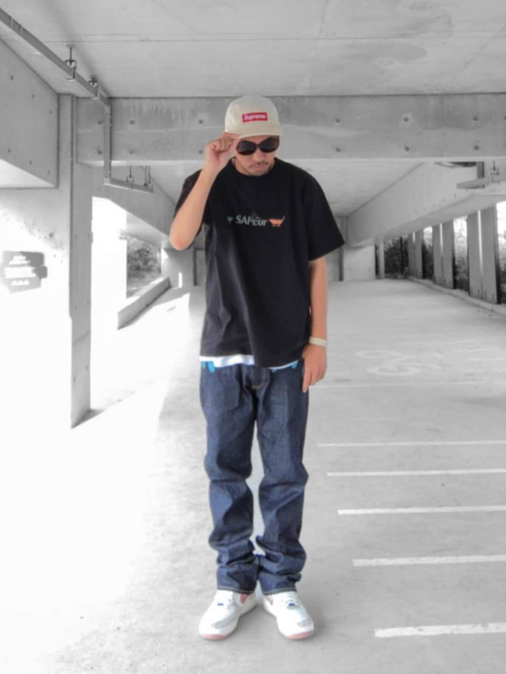 ブラック系のTシャツ/カットソー、ブルー系のデニムパンツ、その他のスニーカーを着用したメンズの夏コーディネートの2枚目の写真