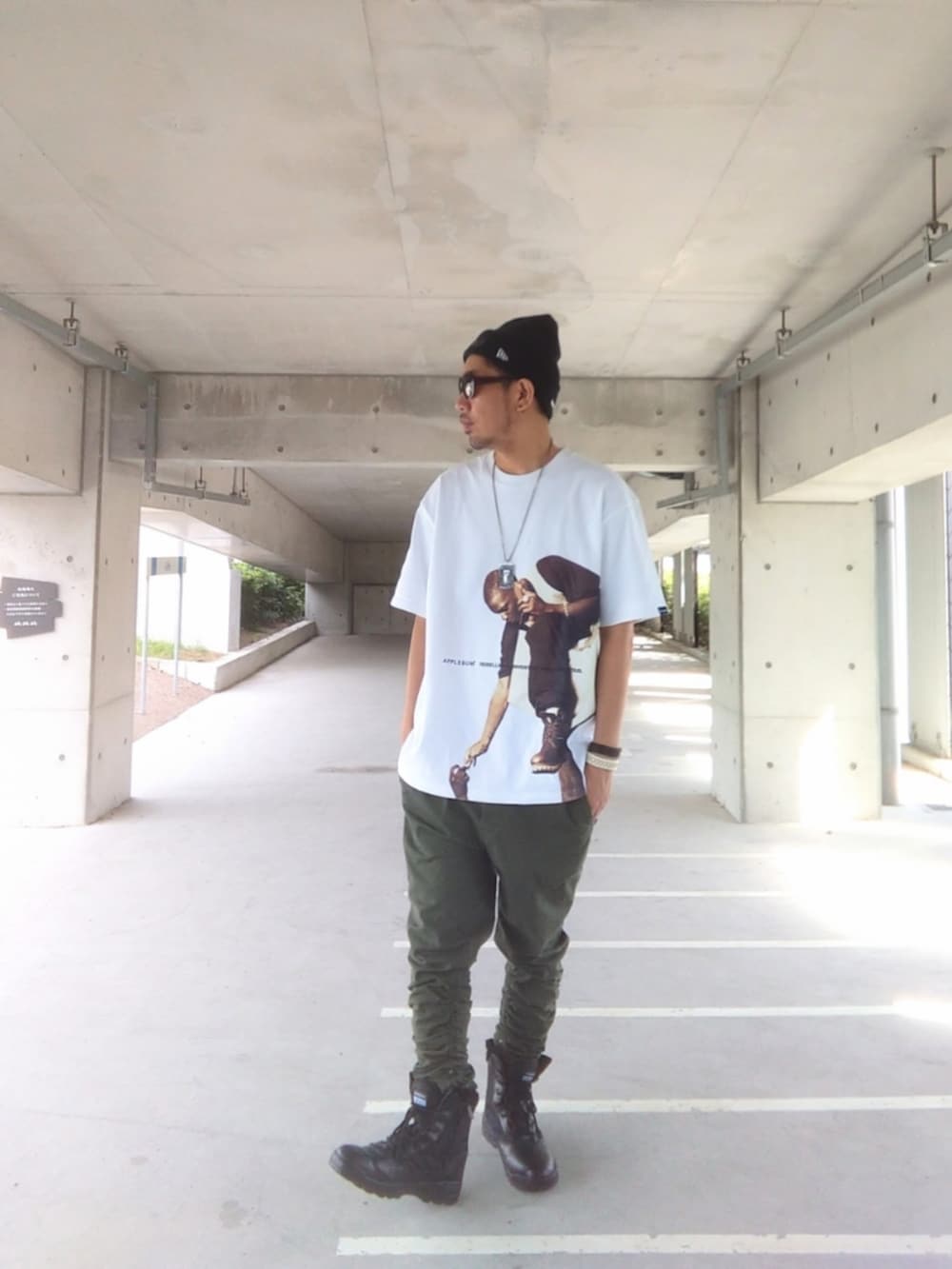 ホワイト系のTシャツ/カットソー、グリーン系のパンツ、ブラック系のブーツを着用したメンズの秋コーディネートの2枚目の写真