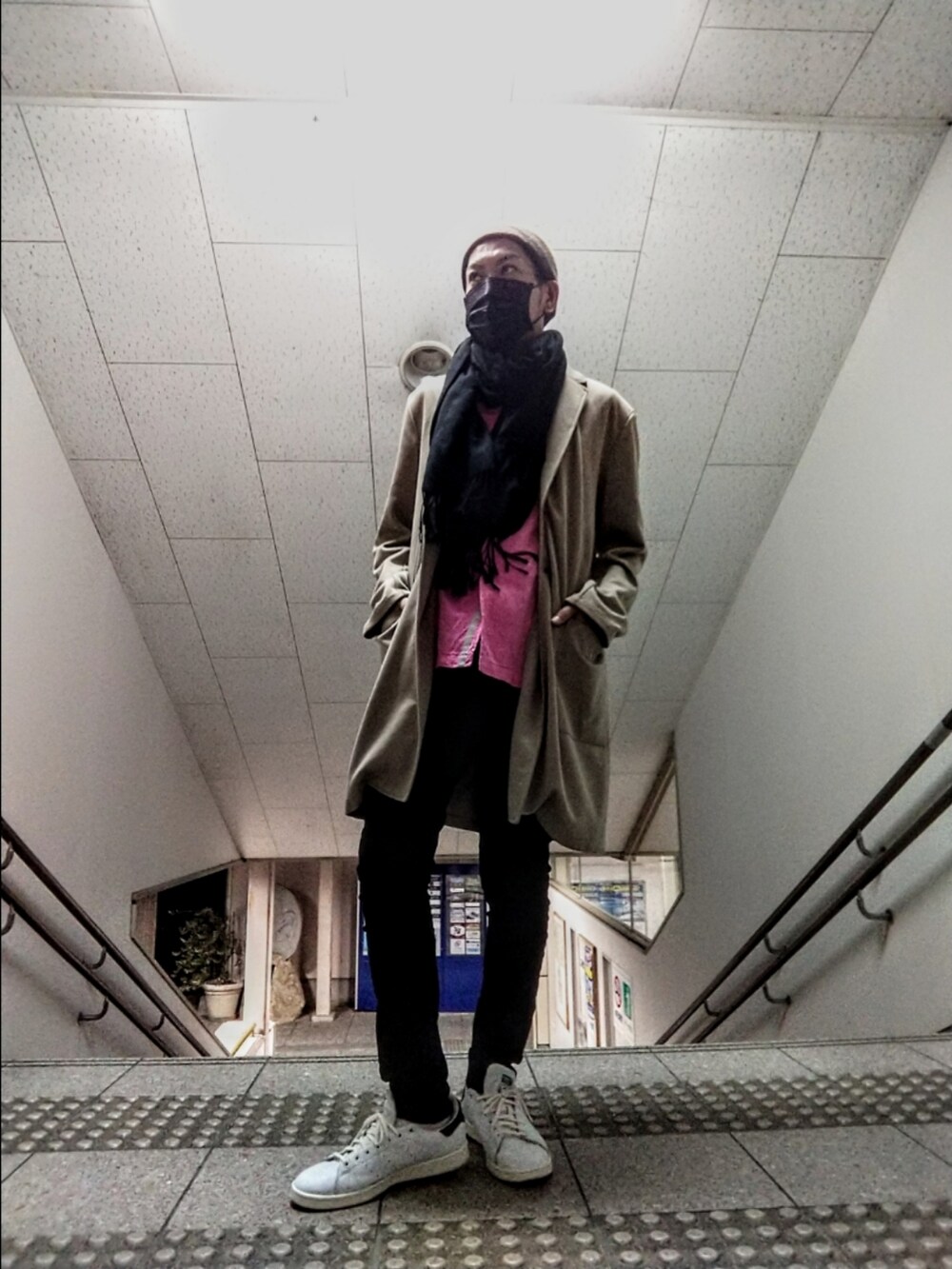 ベージュ系のチェスターコート、ピンク系のシャツ/ブラウス、ブラック系のデニムパンツを着用したメンズの秋コーディネートの2枚目の写真