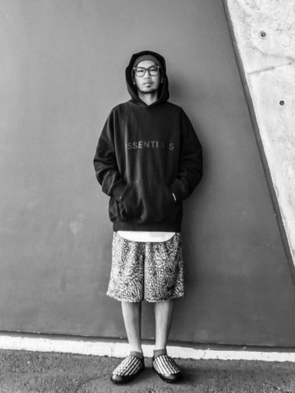 ブラック系のパーカー、ホワイト系のタンクトップ、グレー系のパンツを着用したメンズの冬コーディネートの3枚目の写真