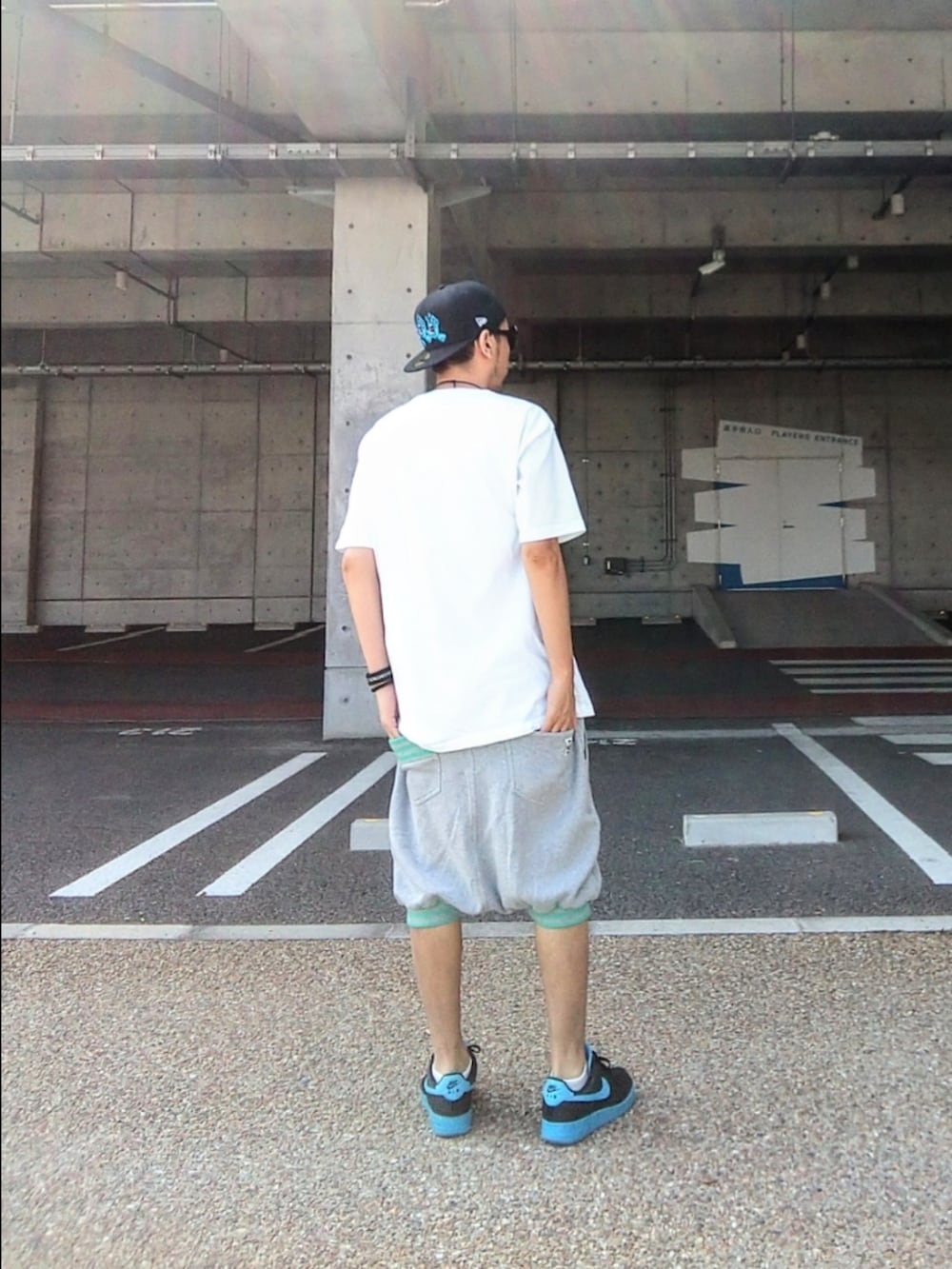 ホワイト系のTシャツ/カットソー、グレー系のその他パンツ、ブルー系のスニーカーを着用したメンズの夏コーディネートの2枚目の写真