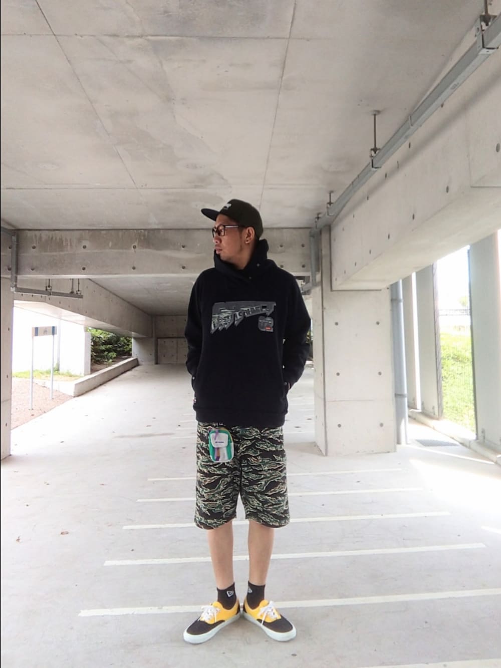 ブラック系のパーカー、その他のパンツ、ブラック系のスニーカーを着用したメンズの春コーディネートの2枚目の写真