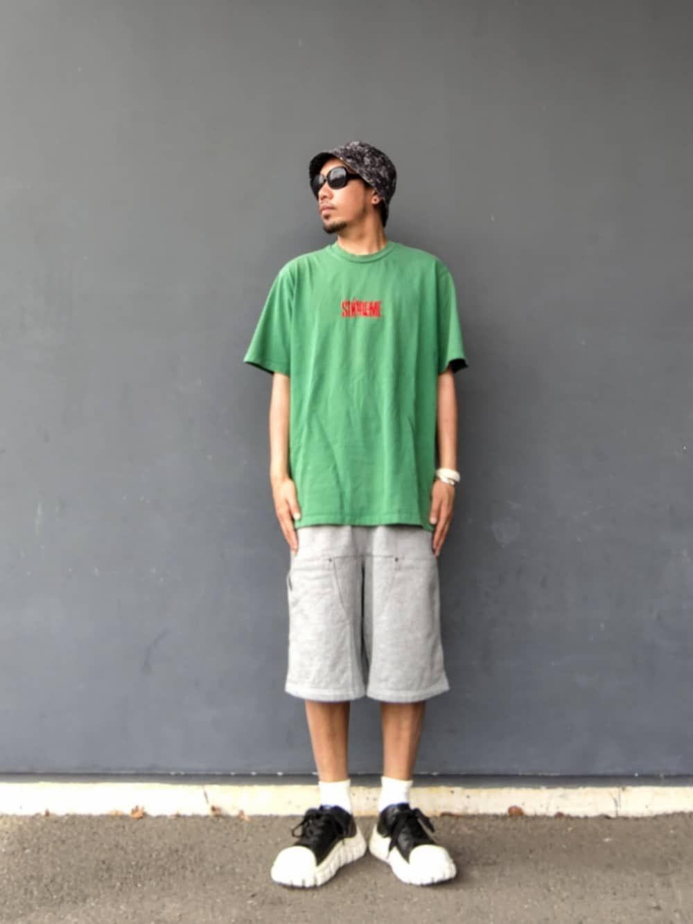 グリーン系のTシャツ/カットソー、グレー系のその他パンツ、その他のスニーカーを着用したメンズの夏コーディネートの2枚目の写真