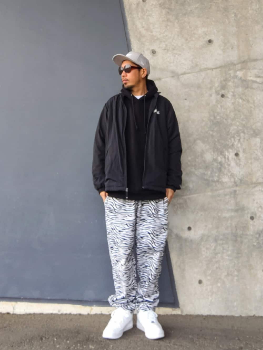 ブラック系のその他アウター、ブラック系のパーカー、ホワイト系のその他パンツを着用したメンズの春コーディネートの2枚目の写真