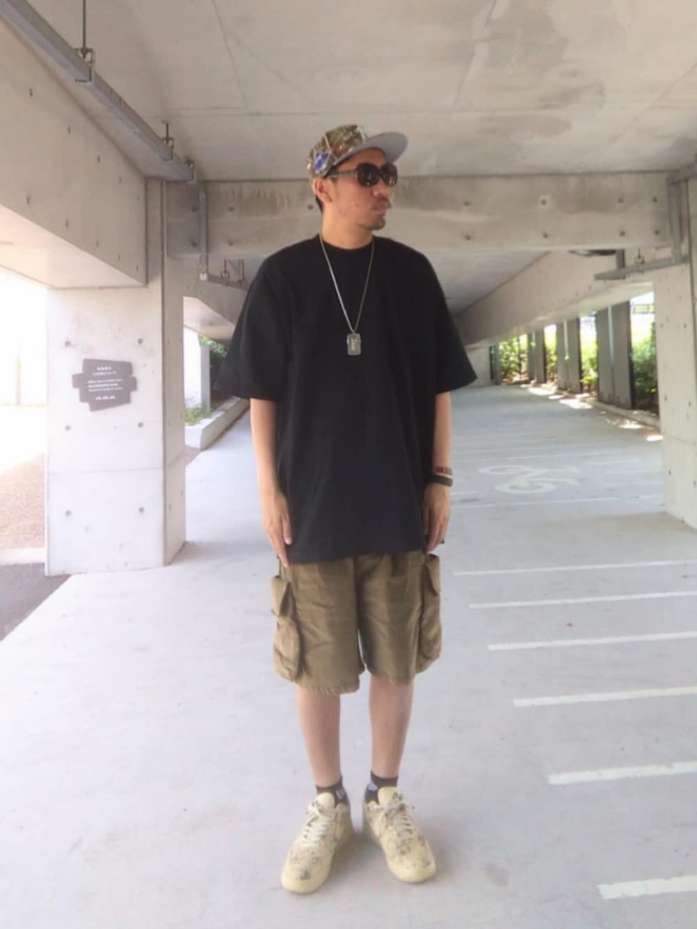 ブラック系のTシャツ/カットソー、グリーン系のその他パンツ、ベージュ系のスニーカーを着用したメンズの夏コーディネートの3枚目の写真