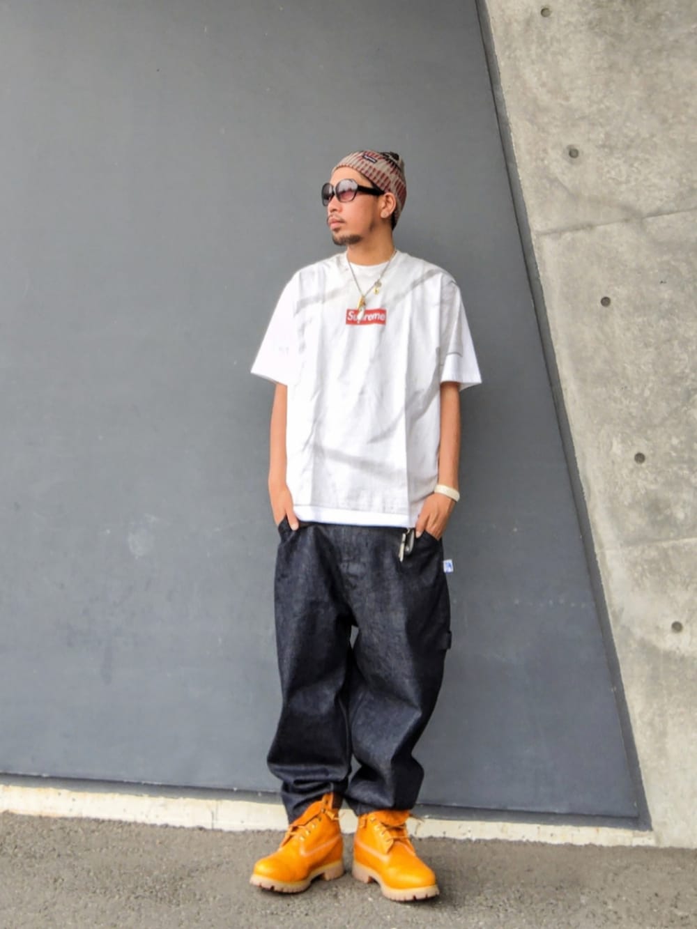 ホワイト系のTシャツ/カットソー、ブラック系のタンクトップ、ブルー系のデニムパンツを着用したメンズの夏コーディネートの2枚目の写真