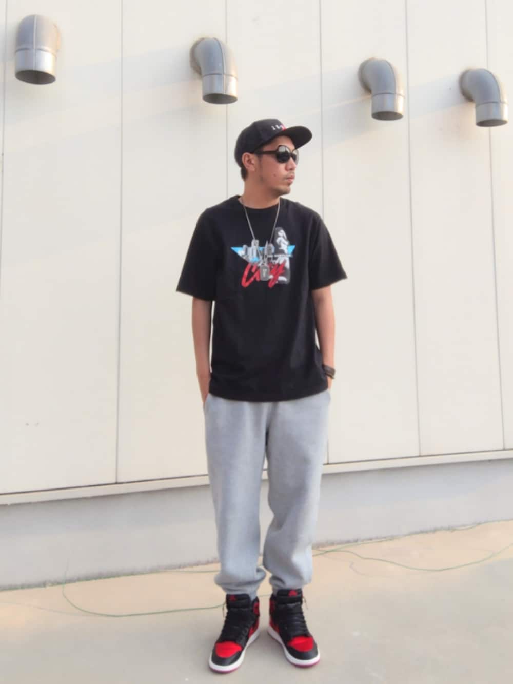 ブラック系のTシャツ/カットソー、グレー系のスウェットパンツ、ブラック系のスニーカーを着用したメンズの秋コーディネートの2枚目の写真