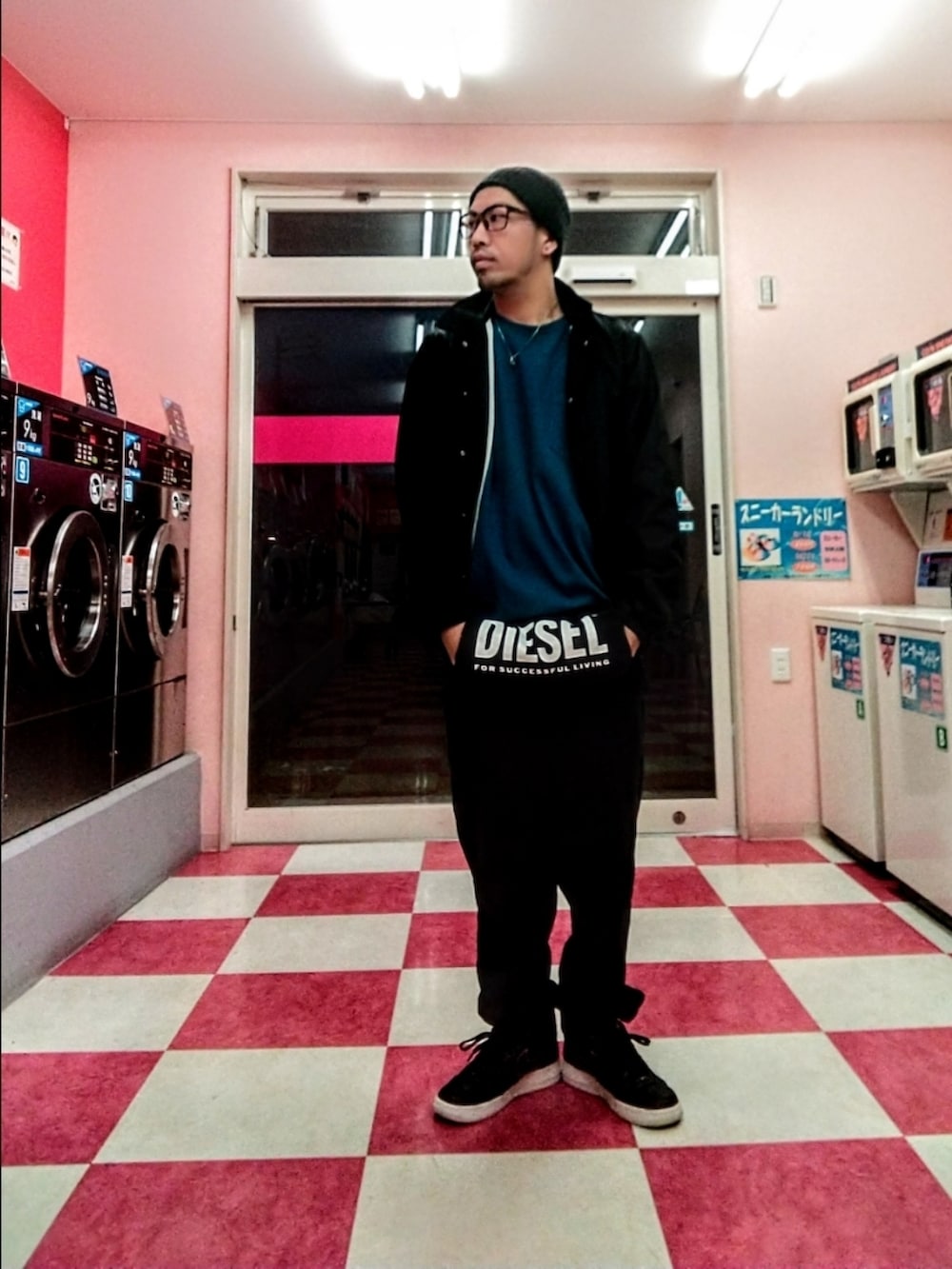 ブルー系のナイロンジャケット、ブルー系のトップス、ブラック系のスウェットパンツを着用したメンズの秋コーディネートの2枚目の写真