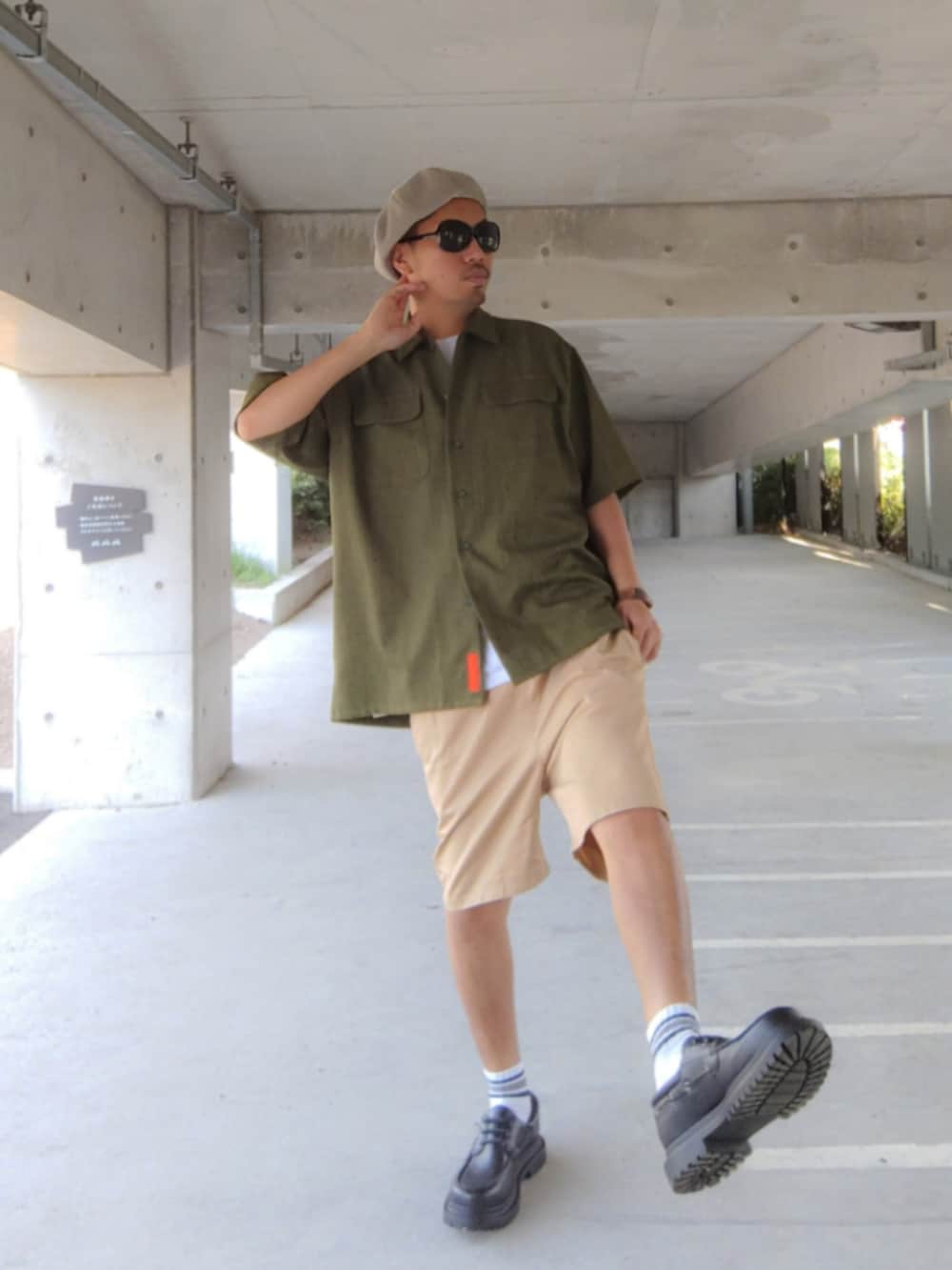 グリーン系のシャツ/ブラウス、ブラック系のモカシン/デッキシューズ、ベージュ系のチノパンツを着用したメンズの秋コーディネートの2枚目の写真