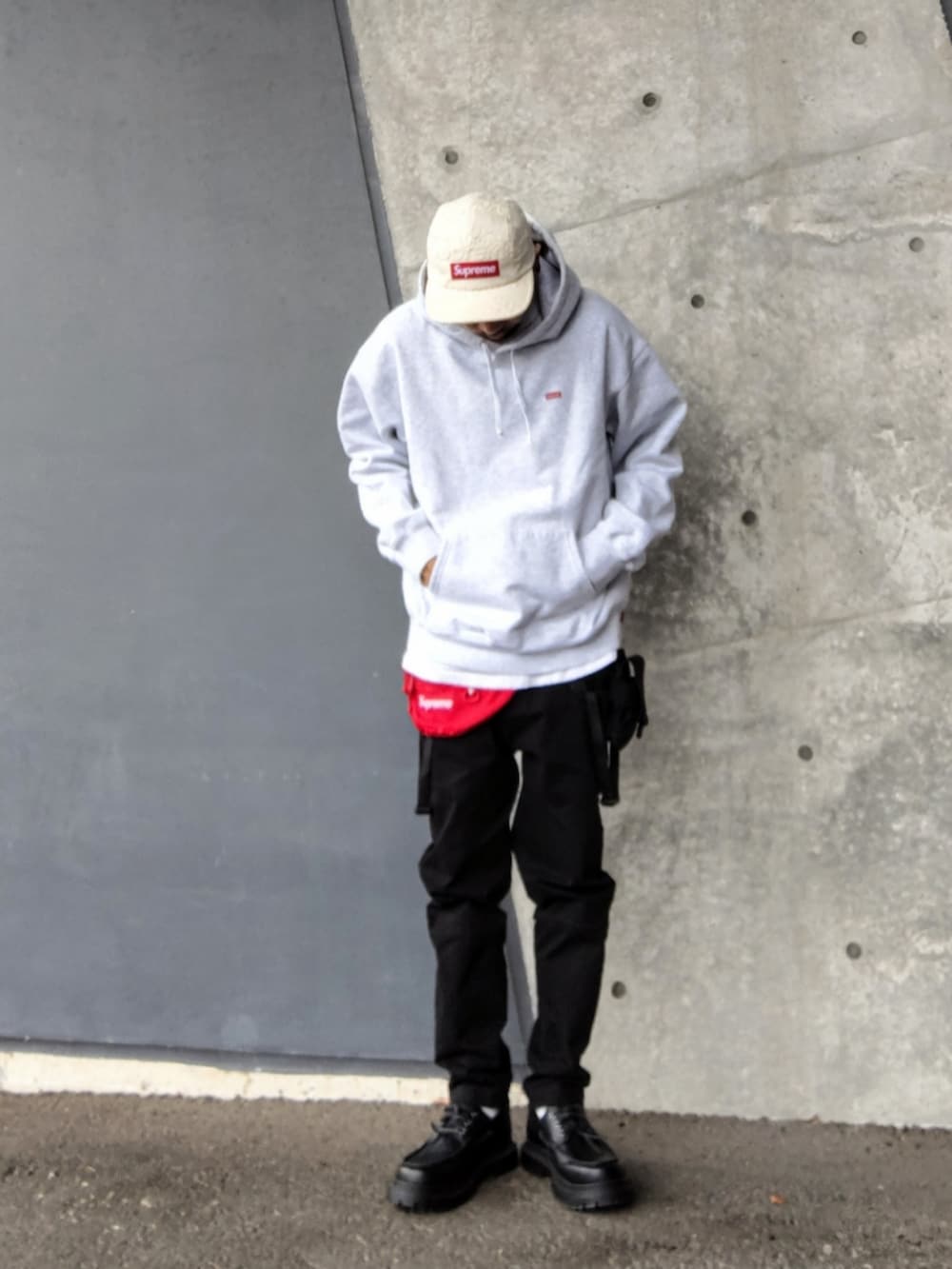 グレー系のパーカー、レッド系のボディバッグ/ウエストポーチ、ブラック系のその他パンツを着用したメンズの春コーディネートの2枚目の写真