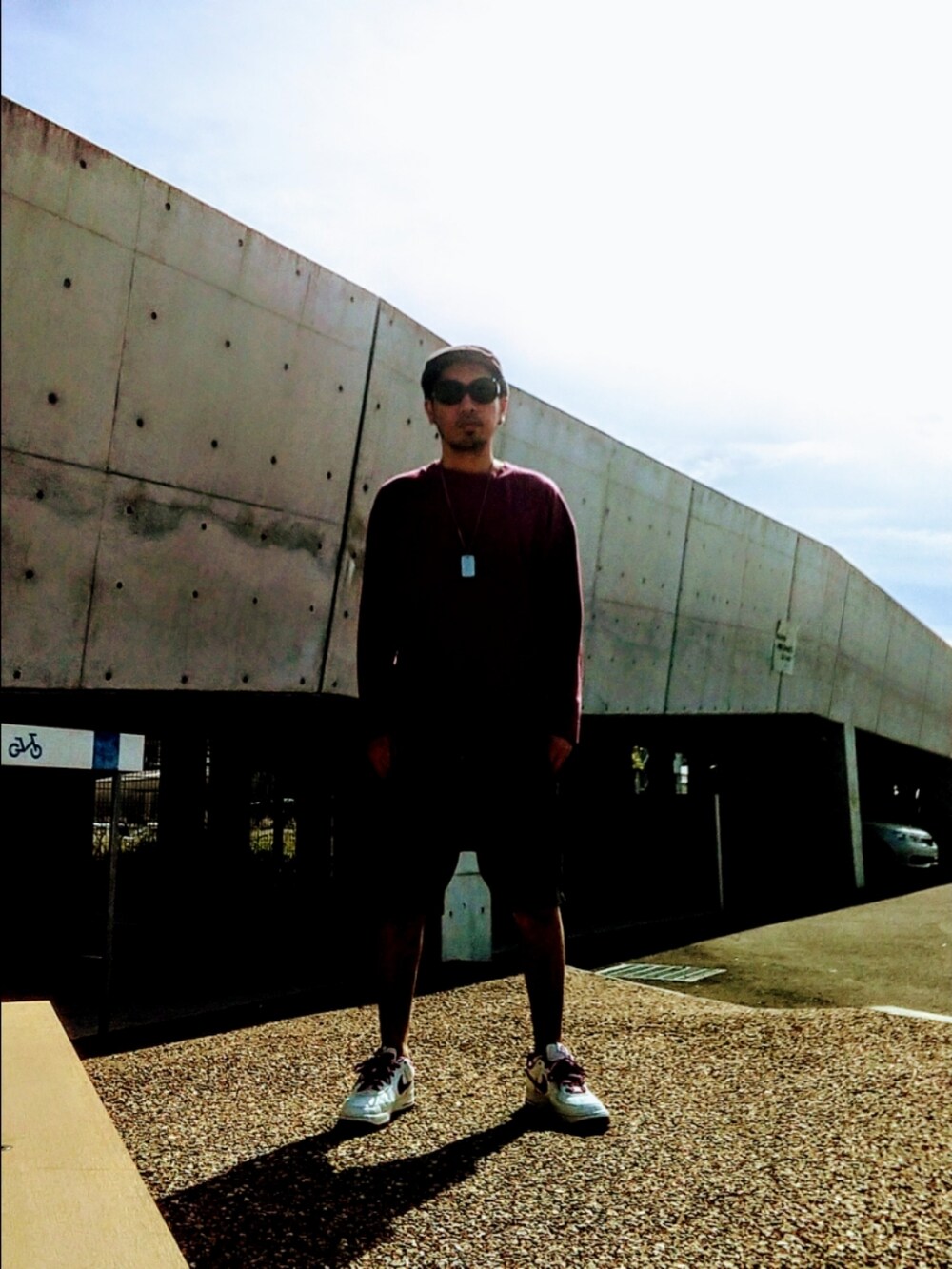 レッド系のTシャツ/カットソー、ブラック系のその他パンツ、ホワイト系のスニーカーを着用したメンズの春コーディネートの3枚目の写真