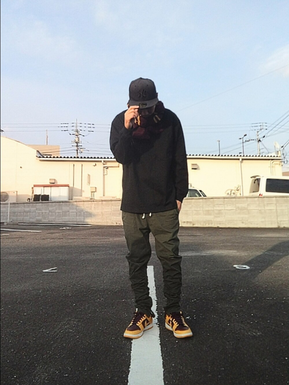 ブラック系のTシャツ/カットソー、グリーン系のパンツ、イエロー系のスニーカーを着用したメンズの冬コーディネートの2枚目の写真