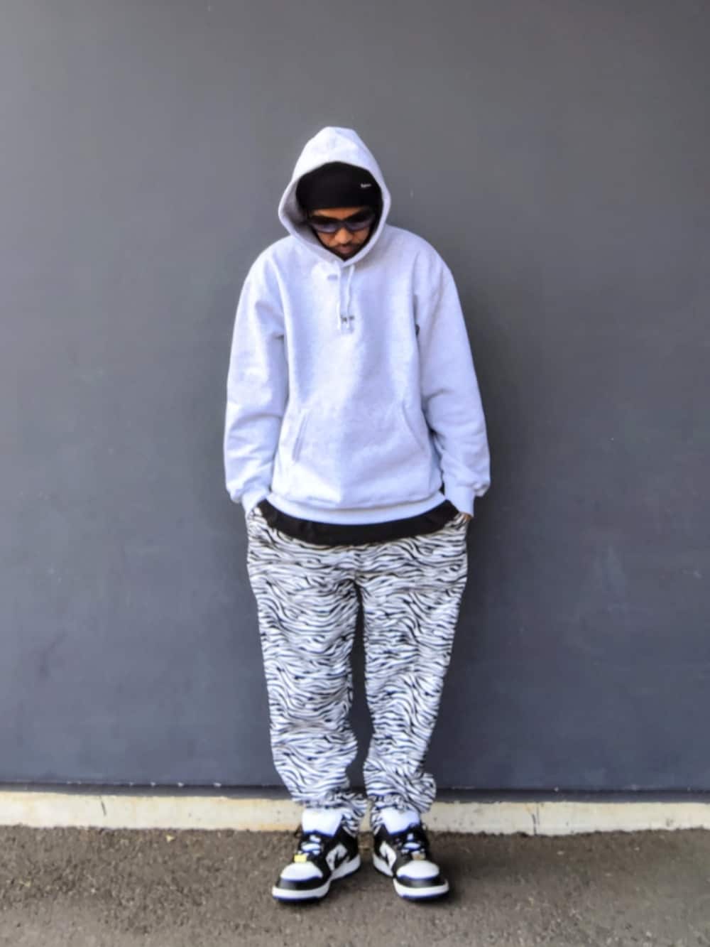 グレー系のパーカー、ブラック系のTシャツ/カットソー、ホワイト系のその他パンツを着用したメンズの冬コーディネートの2枚目の写真