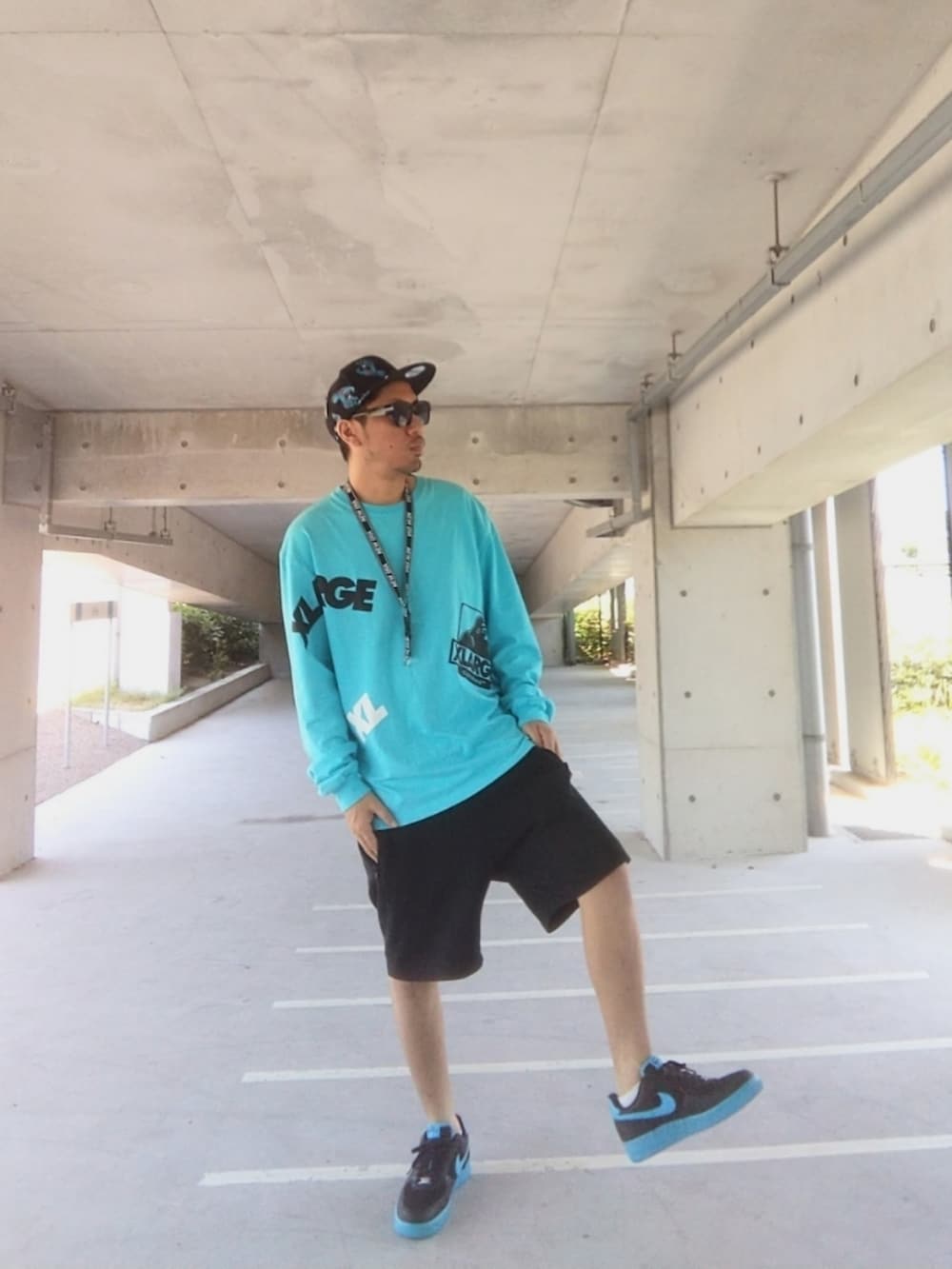 ブルー系のTシャツ/カットソー、ブラック系のその他パンツ、ブルー系のスニーカーを着用したメンズの夏コーディネートの2枚目の写真