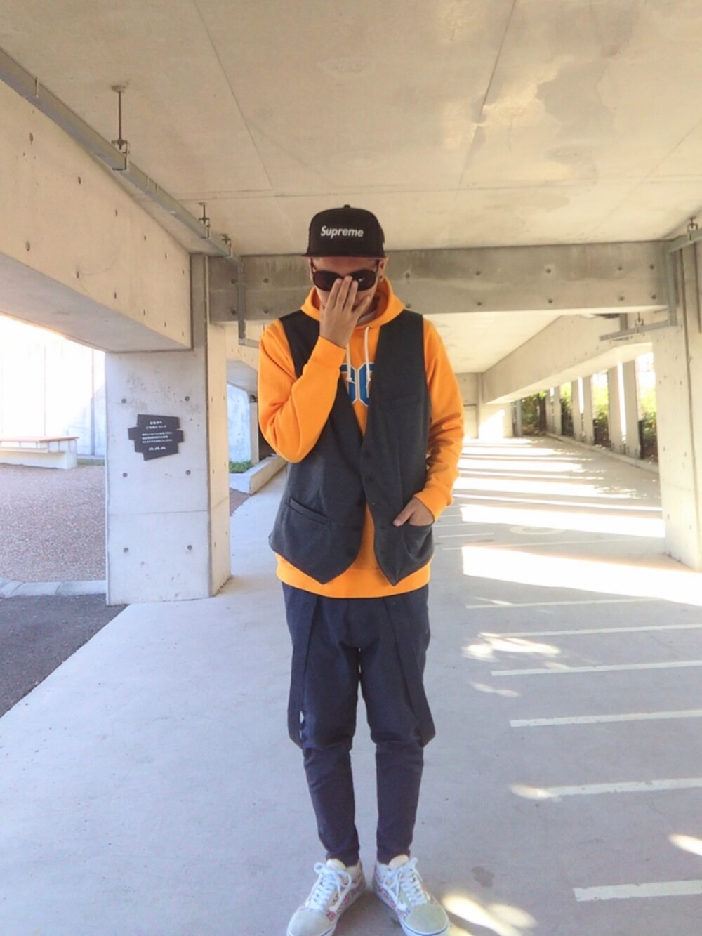 イエロー系のパーカー、グレー系のベスト、ブルー系のその他パンツを着用したメンズの秋コーディネートの4枚目の写真