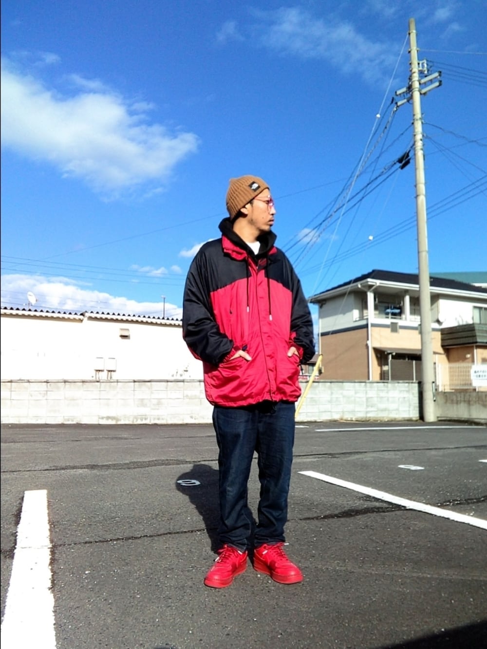 レッド系のその他アウター、ブルー系のデニムパンツ、レッド系のスニーカーを着用したメンズの冬コーディネートの2枚目の写真