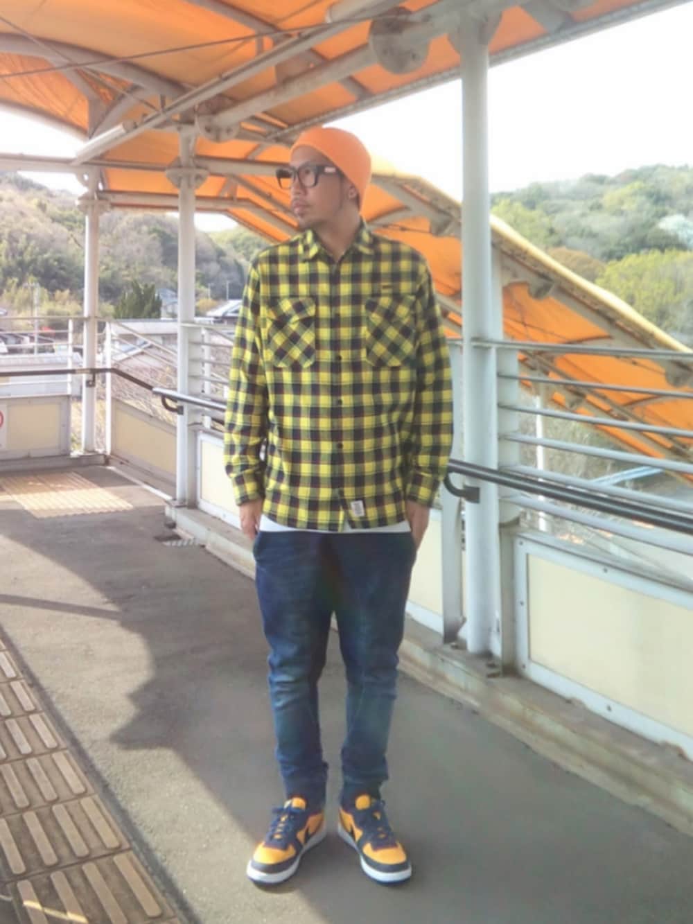 イエロー系のシャツ/ブラウス、ブルー系のパンツ、イエロー系のスニーカーを着用したメンズの春コーディネートの2枚目の写真