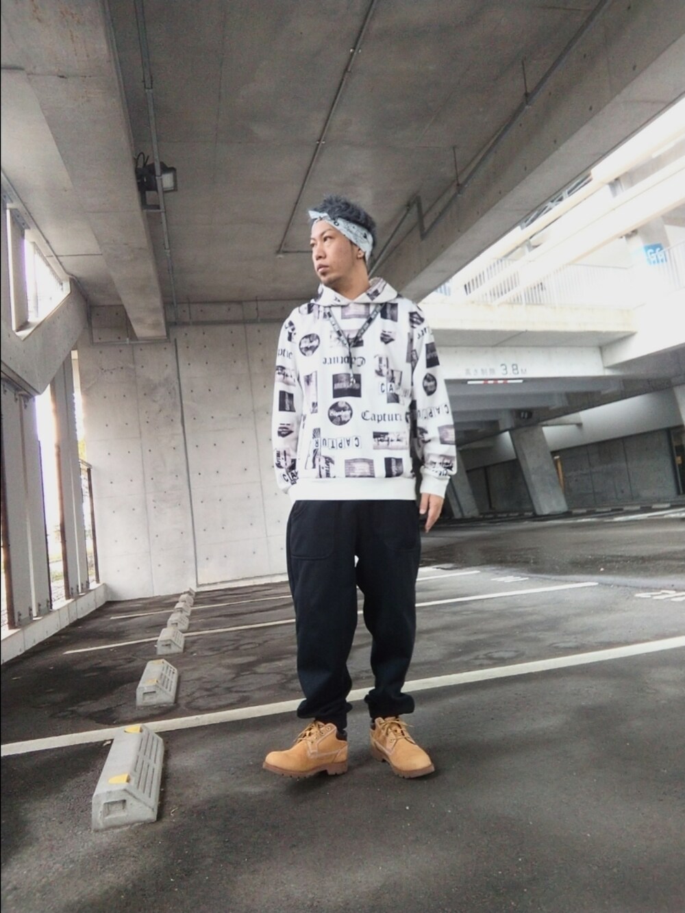 ブラック系のスウェットパンツ、イエロー系のブーツ、ホワイト系のパーカーを着用したメンズの春コーディネートの2枚目の写真