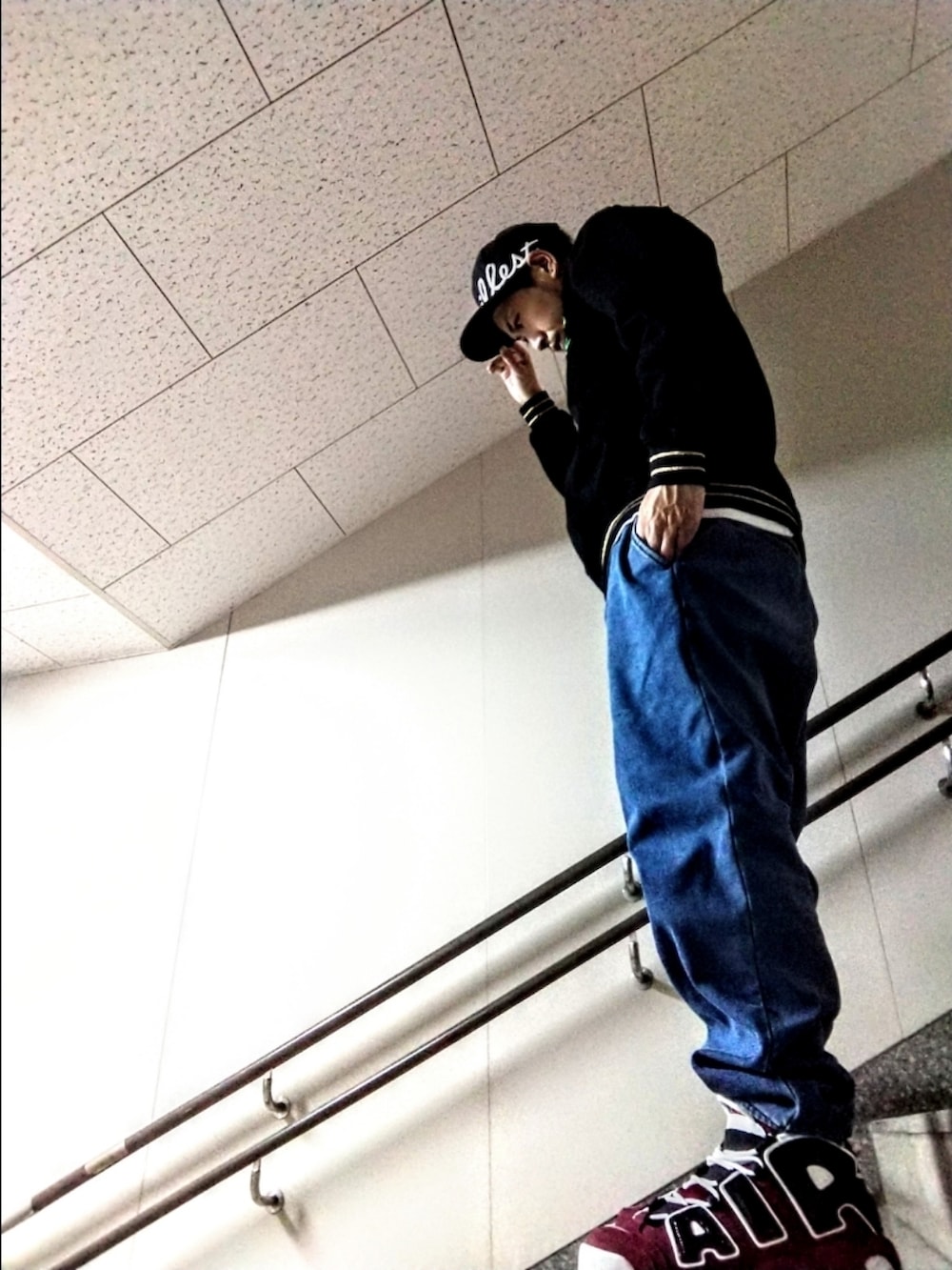 ブラック系のスウェット、ブルー系のデニムパンツ、レッド系のスニーカーを着用したメンズの秋コーディネートの4枚目の写真