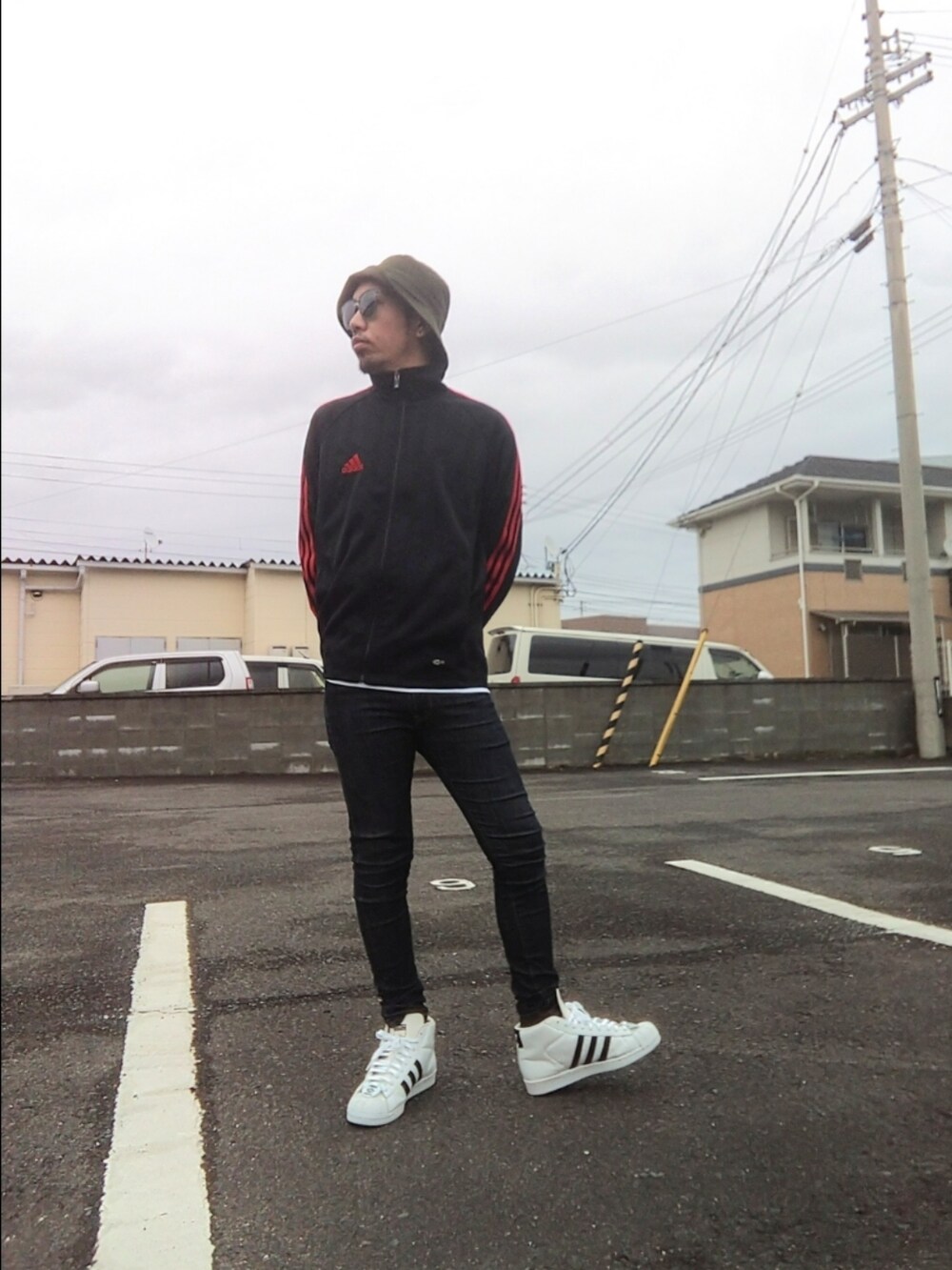 ブラック系のジャージ、ブルー系のデニムパンツ、ホワイト系のスニーカーを着用したメンズの冬コーディネートの2枚目の写真